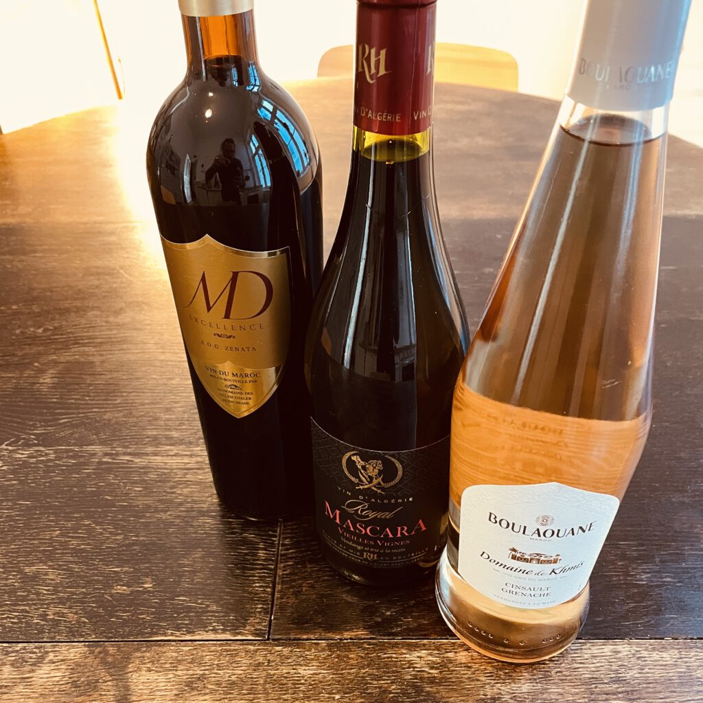 Drei Weinflaschen aus dem Maghreb auf dem Tisch: der MD Excellence, der Royal Mascara and der Boulaouane (Vin gris)